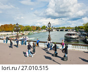 Прохожие на мосту Александра III (Pont Alexandre III). Солнечный день ранней осенью. Париж. Франция (2017 год). Редакционное фото, фотограф E. O. / Фотобанк Лори