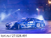 Гоночный автомобиль, дрифтующий в лучах света на 10 фестивале экстремальных видов спорта Прорыв в  спортивном комплексе Олимпийский. Стоковое фото, фотограф Pukhov K / Фотобанк Лори