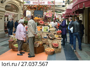 Красочная выставка-ярмарка фермерских продуктов «Отведайте отечественное» в ГУМе. Москва. Посетители покупают овощи и фрукты (2017 год). Редакционное фото, фотограф Валерия Попова / Фотобанк Лори