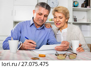 Mature married couple discuss contract and sign important documents. Стоковое фото, фотограф Яков Филимонов / Фотобанк Лори