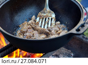 Приготовление плова на огне в казане. Мясо тушится с луком. Стоковое фото, фотограф Елена Коромыслова / Фотобанк Лори