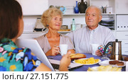 Young woman showing elderly couple something interesting on laptop over cup of tea. Стоковое видео, видеограф Яков Филимонов / Фотобанк Лори