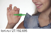 Beautiful cheerful teen girl playing with green fidget spinner on white background stock footage video. Стоковое видео, видеограф Юлия Машкова / Фотобанк Лори