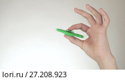 Hands of a teenage girl spin a green fidget spinner on white background stock footage video. Стоковое видео, видеограф Юлия Машкова / Фотобанк Лори