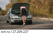 Back of a sexy woman trying to repair a car. Стоковое видео, видеограф Илья Шаматура / Фотобанк Лори