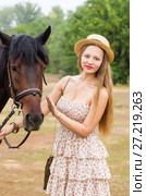Beautiful girl in a straw hat and summer dress posing with a horse / Photo taken in Russia, at the hippodrome of the city of Orenburg. Стоковое фото, фотограф Вадим Орлов / Фотобанк Лори