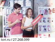 woman and man bayers choosing long rubber phallus in the sex shop. Стоковое фото, фотограф Яков Филимонов / Фотобанк Лори