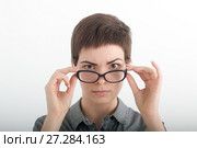 Businesswoman looking sternly over her glasses. Portrait of fashionable brunette woman, looking at camera. Стоковое фото, фотограф Marina Sharova / Фотобанк Лори