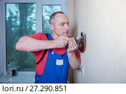 Male electrician connects the lamp on the wall. Стоковое фото, фотограф Наталья Давыдова / Фотобанк Лори