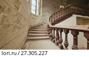A staircase with wooden railing in an abandoned architectural building. The legacy of past architectural times. Handrail stairs made of dark wood. Shooting in motion with electronic stabilization. Стоковое видео, видеограф Mikhail Davidovich / Фотобанк Лори
