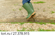 Feet in rubber boots jumping on a puddle. Стоковое видео, видеограф Tatiana Kravchenko / Фотобанк Лори