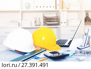 Helmets, level, calculator, roulette on the table. Стоковое фото, фотограф Яков Филимонов / Фотобанк Лори