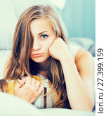 Disappointed girl lying on couch with cushion. Стоковое фото, фотограф Яков Филимонов / Фотобанк Лори