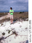 A teenager takes a photograph of  Eastern diamondback rattlesnake  by phone. St George Island State Park, Florida, USA (2017 год). Стоковое фото, фотограф Ирина Кожемякина / Фотобанк Лори
