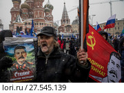 Мужчина держит портрет Сталина во время митинга-концерта "Россия в моем сердце" на Васильевском спуске города Москвы, Россия, 3 февраля 2018. Редакционное фото, фотограф Николай Винокуров / Фотобанк Лори