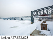 Пролётная конструкция первого железнодорожного моста через реку Обь ( Построен в 1893—1897 годах по проекту Н. А. Белелюбского ) на Михайловской набережной в парке ,, Городское начало ,, на фоне нового моста. Новосибирск, Сибирь, Россия (2018 год). Редакционное фото, фотограф Евгений Мухортов / Фотобанк Лори