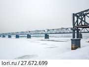 Пролётная конструкция первого железнодорожного моста через реку Обь ( Построен в 1893—1897 годах по проекту Н. А. Белелюбского ) на Михайловской набережной в парке ,, Городское начало ,, на фоне нового моста. Новосибирск, Сибирь, Россия (2018 год). Редакционное фото, фотограф Евгений Мухортов / Фотобанк Лори