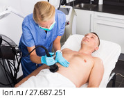 Female specialist is massaging with vacuum to belly of client for anti-fat. Стоковое фото, фотограф Яков Филимонов / Фотобанк Лори
