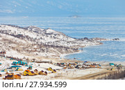 Lake Baikal in the winter. Top view to the frozen strait Small Sea (Maloye More) and the shore with wooden tourist houses (2018 год). Стоковое фото, фотограф Виктория Катьянова / Фотобанк Лори