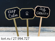 Keep Calm and Defy Gravity message written with chalk on mini blackboard labels. Стоковое фото, фотограф Constantin Stanciu / PantherMedia / Фотобанк Лори