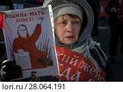Женщина держит плакат Родин - мать зовет! во время марша и митинга КПРФ, посвященного 100-й годовщине Красной армии на Страстном бульваре в центре города Москвы, Россия, 23 февраля 2018. Редакционное фото, фотограф Николай Винокуров / Фотобанк Лори