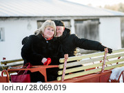 Счастливая пара. Влюблённые мужчина и женщина среднего возраста сидят на телеге (2018 год). Редакционное фото, фотограф Игорь Низов / Фотобанк Лори