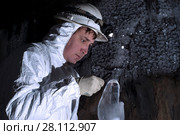 Cave explorer carefully examines the structure of the ice formations through a magnifying glass. Стоковое фото, фотограф Евгений Харитонов / Фотобанк Лори