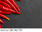 Fresh ripe red hot chili peppers on a black background. Стоковое фото, фотограф Иван Карпов / Фотобанк Лори