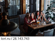 Four friends look at the phone and laugh. Стоковое фото, фотограф Виктор Аллин / Фотобанк Лори