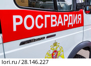 Inscription "Rosgvardia" and emblem of the troops of the National Guard of the Russian Federation on the board of car (2017 год). Редакционное фото, фотограф FotograFF / Фотобанк Лори