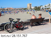Люди отдыхают после велопрогулки. Пляж Playa de Las Vistas в городе Los Cristianos. Атлантический океан, остров Тенерифе, Канары, Испания (2016 год). Редакционное фото, фотограф Кекяляйнен Андрей / Фотобанк Лори
