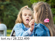 Одна девочка угощает другую девочку своим леденцом на палочке. Стоковое фото, фотограф Иванов Алексей / Фотобанк Лори