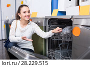 young girl choosing new dish washing machine in supermarket. Стоковое фото, фотограф Яков Филимонов / Фотобанк Лори