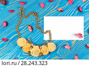 Handmade necklace consisting of five flowers and a greeting card with congratulations on a blue wooden background. Стоковое фото, фотограф Олег Белов / Фотобанк Лори