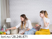 Two young girls are sitting on the couch. Стоковое фото, фотограф Типляшина Евгения / Фотобанк Лори