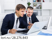 cheerful two men coworkers working on computers in firm office. Стоковое фото, фотограф Яков Филимонов / Фотобанк Лори