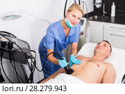 Woman doctor is doing vacuum massage procedure on belly of adult client. Стоковое фото, фотограф Яков Филимонов / Фотобанк Лори