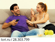 Couple on sofa quarreling because of TV remote. Стоковое фото, фотограф Яков Филимонов / Фотобанк Лори
