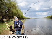 Рыбак ловит рыбу на берегу реки "Кривой бузан" весенним днём. Красный Яр. Астраханская область (2018 год). Редакционное фото, фотограф Игорь Низов / Фотобанк Лори