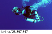 Two scuba divers man and woman on safety stop in the blue water - Indian Ocean, Fuvahmulah island, Maldives (2018 год). Редакционное видео, видеограф Некрасов Андрей / Фотобанк Лори