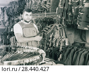 Young guy choosing flak jacket in military shop. Стоковое фото, фотограф Яков Филимонов / Фотобанк Лори