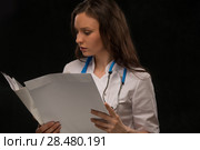 Female doctor reading medical record. Стоковое фото, фотограф Kirill Kedrinskiy / Ingram Publishing / Фотобанк Лори