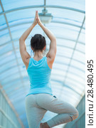 Woman practicing yoga outdoors on the bridge. Стоковое фото, фотограф Kirill Kedrinskiy / Ingram Publishing / Фотобанк Лори
