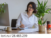 Woman writing at office during working day. Стоковое фото, агентство Ingram Publishing / Фотобанк Лори