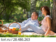 Adult couple picnicking in the summer park under the tree. Стоковое фото, фотограф Kirill Kedrinskiy / Ingram Publishing / Фотобанк Лори