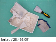 Platering tools for plaster like plaste trowel spatula on green drywall plasterboard. Стоковое фото, фотограф Tono Balaguer / Ingram Publishing / Фотобанк Лори