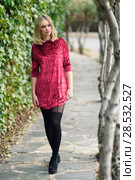 Beautiful blonde woman in urban background. Young girl wearing red dress and tights standing in the street. Pretty female with straight hairstyle and blue eyes. Стоковое фото, фотограф Javier Sánchez Mingorance / Ingram Publishing / Фотобанк Лори