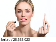 Beautiful woman with clean fresh skin applying pink lip gloss. Skin care face. Cosmetology. Blonde girl with blue eyes. Стоковое фото, фотограф Javier Sánchez Mingorance / Ingram Publishing / Фотобанк Лори
