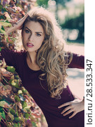 Beautiful woman with long blond curly hair in urban background. Стоковое фото, фотограф Javier Sánchez Mingorance / Ingram Publishing / Фотобанк Лори