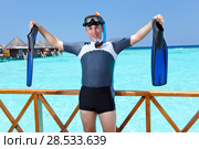 Sports man with flippers, mask and tube on sundeck of a house over the sea. Maldives. Стоковое фото, фотограф Куликов Константин / Фотобанк Лори